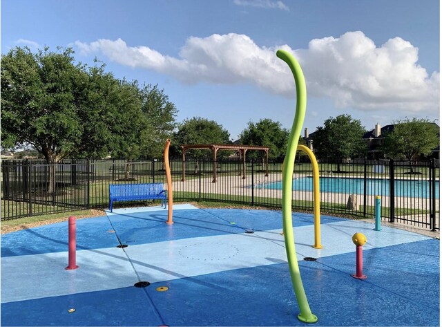 view of property's community featuring fence and playground community