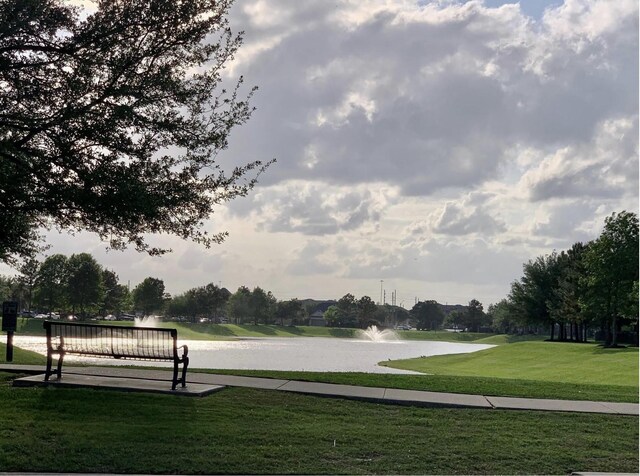 view of property's community with a yard and a water view