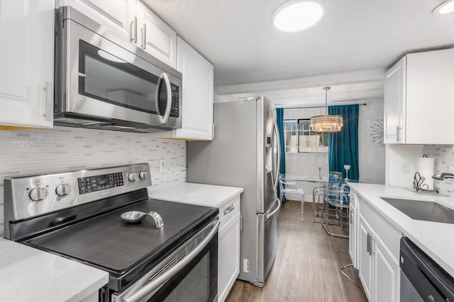 9502 Windswept Ln Unit 9502, Houston, TX 77063 - kitchen with a sink, appliances with stainless steel finishes, dark wood finished floors, and white cabinetry