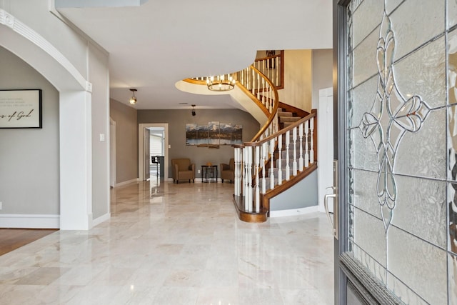 7711 Oxfordshire Dr, Spring, TX 77379 - foyer featuring marble finish floor, stairs, baseboards, a chandelier, and arched walkways
