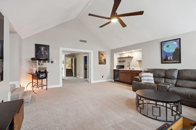 7711 Oxfordshire Dr, Spring, TX 77379 - living area with ceiling fan, light colored carpet, high vaulted ceiling, indoor wet bar, and stairway