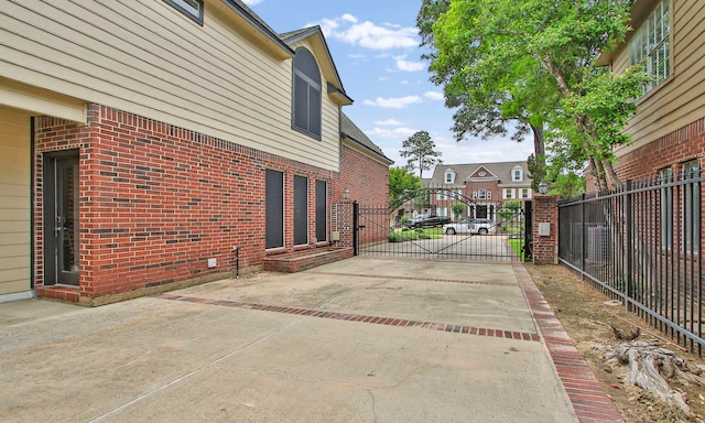 7711 Oxfordshire Dr, Spring, TX 77379 - view of patio with a gate, fence, a residential view, and concrete driveway