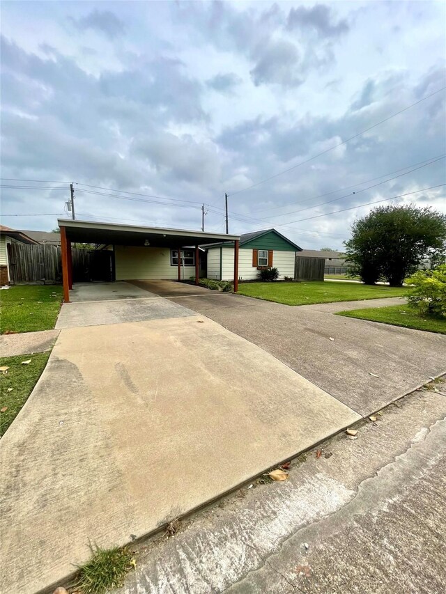 view of front of property featuring driveway, a front yard, and a carport