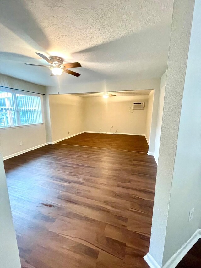 unfurnished room with a textured ceiling, baseboards, a ceiling fan, and wood finished floors