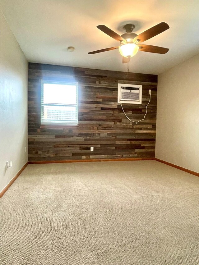 carpeted empty room with wooden walls, ceiling fan, a wall unit AC, and baseboards