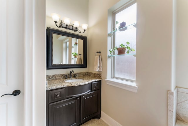 bathroom with vanity, baseboards, and tile patterned flooring