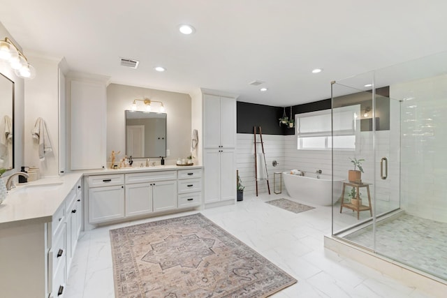 bathroom with a sink, a freestanding tub, a stall shower, and recessed lighting