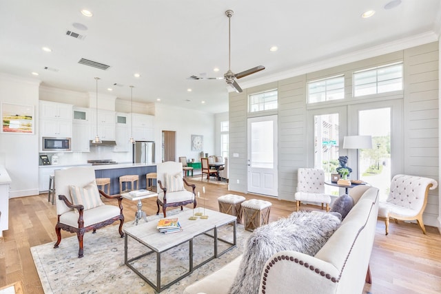 living area featuring visible vents and crown molding