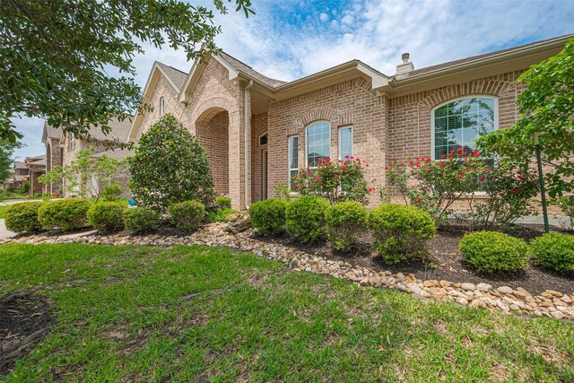view of front of home featuring a front lawn and brick siding