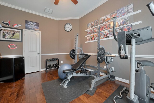 workout area featuring baseboards, ornamental molding, a ceiling fan, and wood finished floors