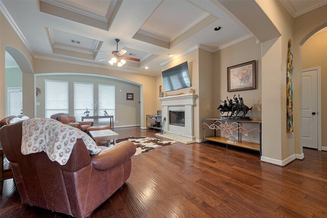 living area with a ceiling fan, visible vents, arched walkways, wood finished floors, and baseboards