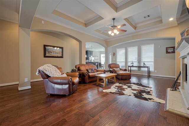 living room featuring a ceiling fan, visible vents, arched walkways, dark wood finished floors, and a fireplace with raised hearth