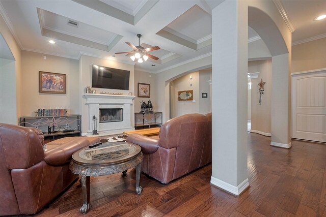 living room featuring a ceiling fan, ornamental molding, baseboards, dark wood-style floors, and arched walkways