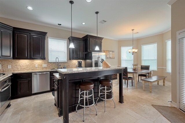 kitchen featuring appliances with stainless steel finishes, a breakfast bar, a center island, decorative backsplash, and visible vents