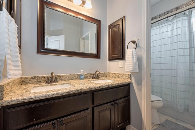 bathroom with a sink, shower / bath combo, toilet, and double vanity