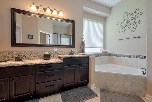 bathroom featuring double vanity, tile patterned floors, a bath, and a sink
