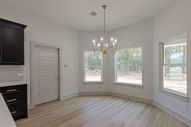 79 Rd 6606, Dayton, TX 77535 - unfurnished dining area featuring visible vents, baseboards, an inviting chandelier, and light wood-type flooring