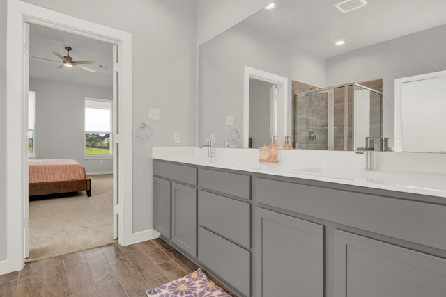 18331 Yaupon Bough Ln, Tomball, TX 77377 - bathroom featuring double vanity, baseboards, wood tiled floor, a shower stall, and a sink