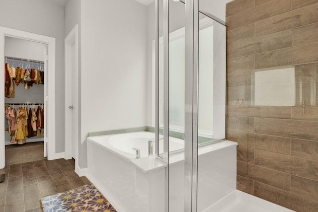 18331 Yaupon Bough Ln, Tomball, TX 77377 - bathroom featuring baseboards, a stall shower, a garden tub, and a spacious closet