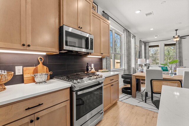 kitchen with light countertops, appliances with stainless steel finishes, and light wood-style floors