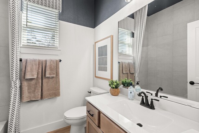 bathroom featuring vanity, toilet, and wood finished floors