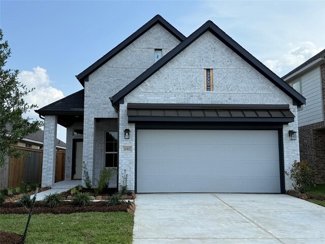 traditional-style house with brick siding, fence, and concrete driveway