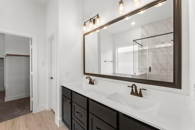 21517 Witham Promenade Ln, Magnolia, TX 77355 - full bath featuring a stall shower, wood finished floors, double vanity, and a walk in closet