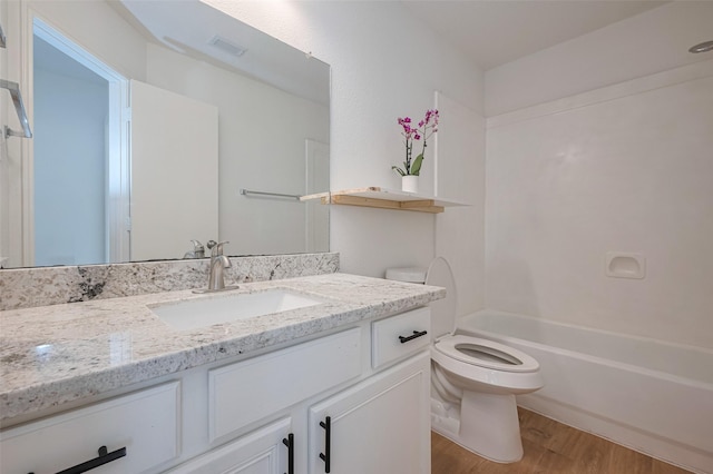 bathroom featuring shower / bathing tub combination, visible vents, wood finished floors, vanity, and toilet