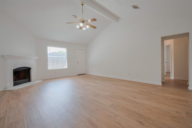 unfurnished living room with light wood finished floors, a fireplace with raised hearth, a ceiling fan, beamed ceiling, and visible vents