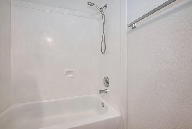 full bathroom featuring shower / bath combination and a textured wall