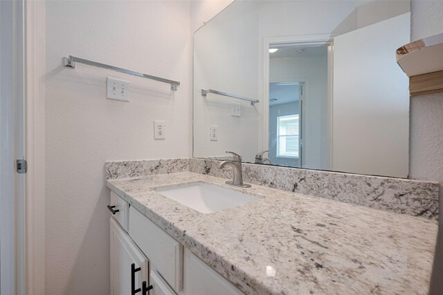 bathroom with vanity and a textured wall