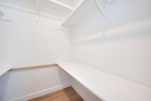 spacious closet with wood finished floors and built in study area
