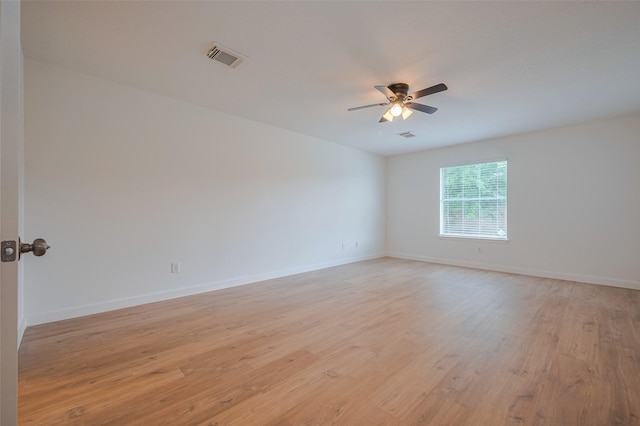 unfurnished room with light wood-type flooring, a ceiling fan, baseboards, and visible vents