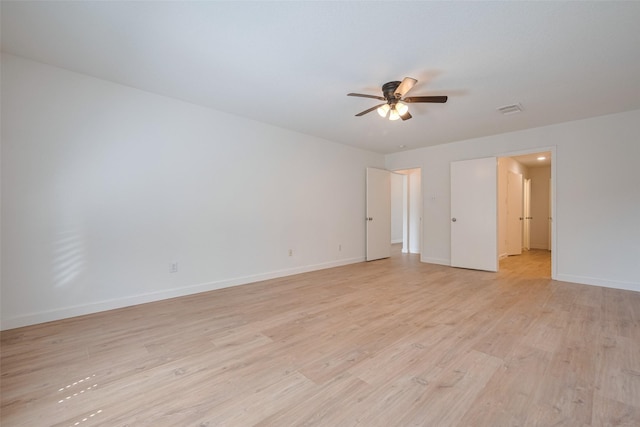 spare room featuring visible vents, light wood-style flooring, ceiling fan, and baseboards