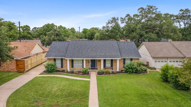 view of front facade with roof with shingles, a front yard, a porch, and brick siding