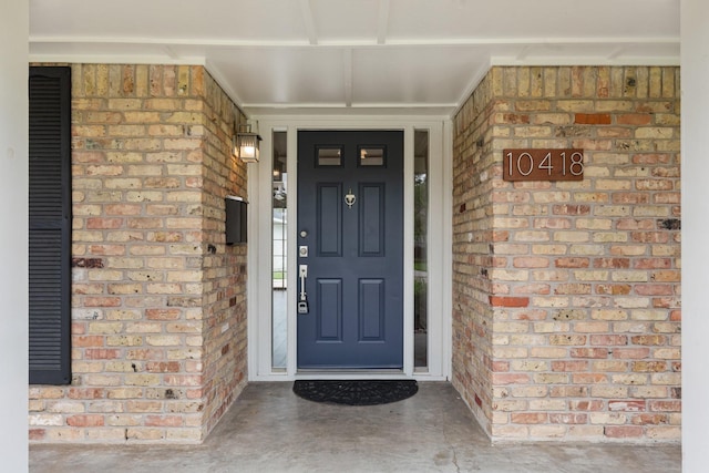 property entrance featuring brick siding