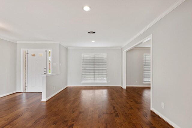 interior space featuring baseboards, visible vents, ornamental molding, and wood finished floors