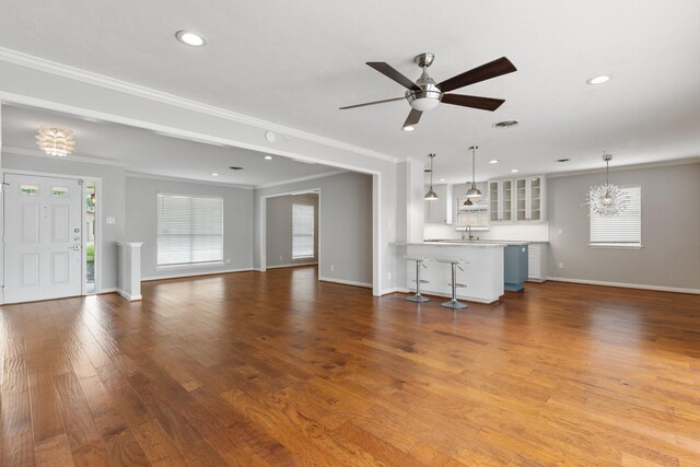unfurnished living room with crown molding, baseboards, recessed lighting, and a healthy amount of sunlight
