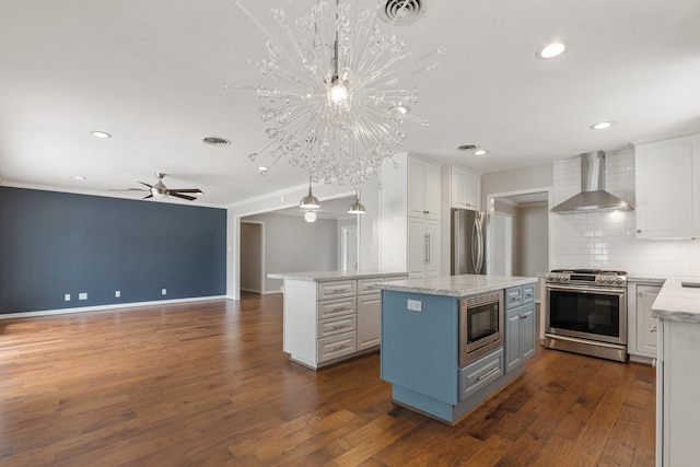 kitchen with a center island, tasteful backsplash, white cabinets, stainless steel appliances, and wall chimney exhaust hood