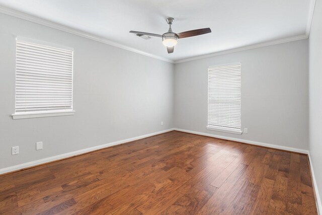 unfurnished room with visible vents, ornamental molding, baseboards, and wood finished floors