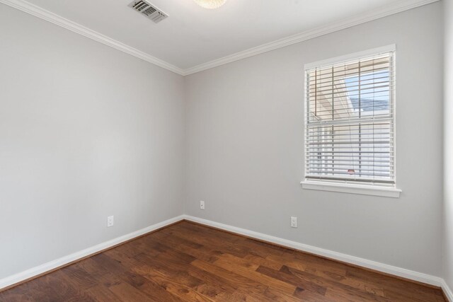unfurnished room with crown molding, baseboards, dark wood-style flooring, and visible vents