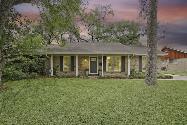 single story home with brick siding, a front lawn, and roof with shingles