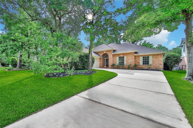 single story home with brick siding, a front lawn, an attached garage, and driveway