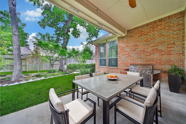 view of patio featuring grilling area, a ceiling fan, outdoor dining area, exterior kitchen, and fence
