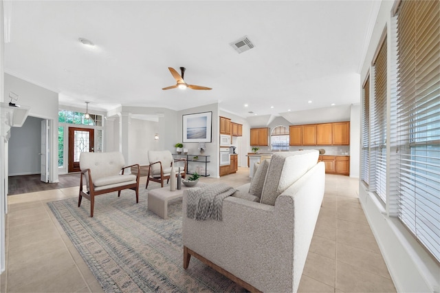 living room with visible vents, decorative columns, baseboards, a ceiling fan, and light tile patterned floors