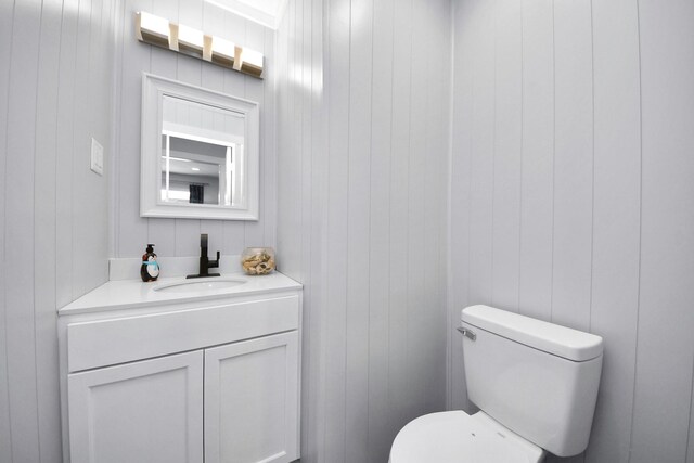 6102 Ghana Ln, Pasadena, TX 77505 - bathroom with toilet, vanity, and wooden walls