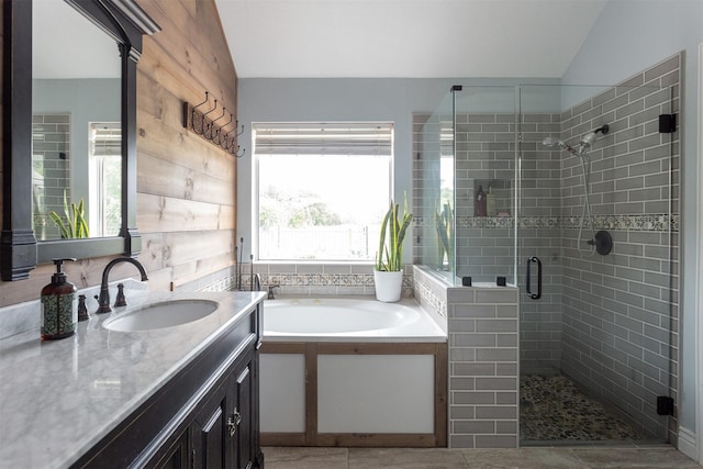 full bathroom featuring vaulted ceiling, vanity, a shower stall, and a bath