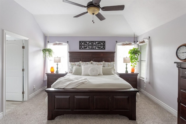 bedroom with baseboards, light carpet, and lofted ceiling