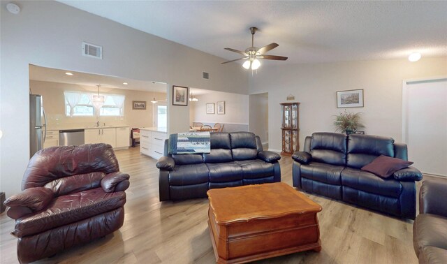 living room featuring visible vents, a ceiling fan, and light wood-type flooring