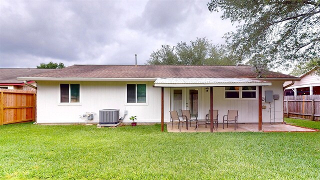 back of property featuring a yard, central AC, a fenced backyard, and a patio area